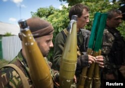 Separatiști pregătindu-și aruncătoarele de grenade in regiunea Donețkului, 19 iunie 2014.