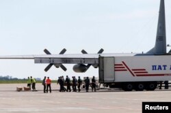 Coșciugele sînt încărcate pe avionul ce le duce la Amsterdam.