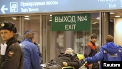 Russia -- A victim of a bomb explosion is wheeled out by medics at Moscow's Domodedovo airport, 24Jan2011