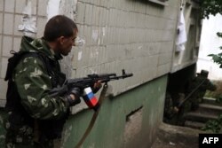 Luptător separatist trage în forțele guvernului în Lihansk.