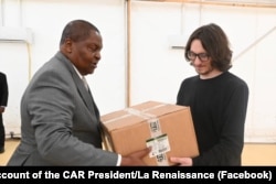 In a photograph posted to the C.A.R. president's Facebook page, Dmitry Syty (right) is shown handing over boxes of medical supplies to President Faustin-Archange Touadera in February 2025.