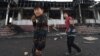Kazakhstan - Kordai - Youth walk past a burnt out building in the village of Masanchi some 250 kilometres from Almaty on February 8, 2020. - Eight people were killed, dozens hurt and property burned during clashes between ethnic Kazakhs and members of the