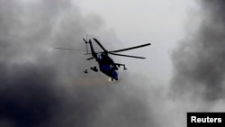 Elicopter ucrainean Mi-24 trage asupra rebelilor pro-ruși care au ocupat aeroportul din Donețk.