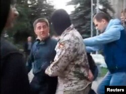 Adjunctul primarului din Horlivka, Volodimir Rîbak, fidel Kievului, filmat pe 7 aprilie in momentul in care a fost luat de oameni mascati care l-au torturat și ucis.