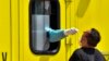 NORTH MACEDONIA -- Medical w, orker wearing a protective suit co, llects nasopharyngeal swab samples to test for the SARS-CoV-2 coronavirus causing the COVID-19 disease, through the small window of an ambulance in the garden of private clinic 'Zan Mitrev'
