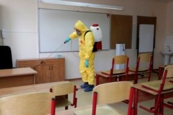 Сыныпты дезинфекциялап жатқан маман. Көрнекі сурет.