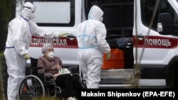 Коронавирус жұққан адамды ауруханаға әкелген медицина қызметкерлері. 