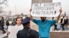 RUSSIA -- A Russian police officer speaks with an opposition supporter holding a poster reading "No war, repressions and tortures!" during a rally in support of jailed Kremlin critic Aleksei Navalny in Vladivostok, April 21, 2021