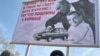 Россия, Владивосток. Митингующие держат растяжку с карикатурой на Владимира Путина и Дмитрия Медведева, февраль 2009
