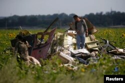 Un anchetator malaezian la locul prăbușirii avionului.