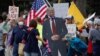 USA -- A cardboard cutout of U.S. President Donald Trump wearing a mask is brought to a protest over the stay-at-home orders involving the closing of beaches and walking paths during the outbreak of the coronavirus disease (COVID-19) in Encinitas, Califor