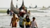 BANGLADESH -- Rohingya refugees walk to the shore with his belongings after crossing the Bangladesh-Myanmar border by boat through the Bay of Bengal in Teknaf, Bangladesh, September 5, 2017