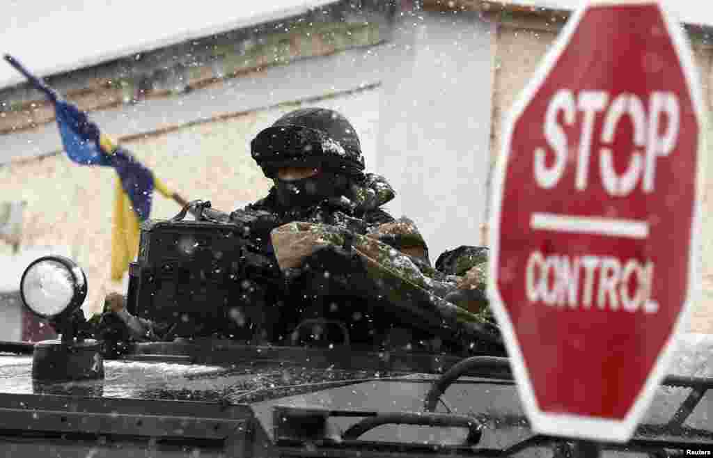 Меркаваны расейскі вайсковец на варце каля ўкраінскай ваеннай базы ў Перавальным непадалёк ад Сімфэропаля.