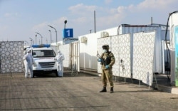 Әскери бөлімше аумағынан ашылған коронавирус жұққандарды емдейтін уақытша аурухананы күзетіп тұрған сақшылар. Ташкент, мамыр айы 2020 жыл.