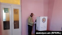 Armenia - A man in Odzun village appears to give guidance to an elderly voter, 5Nov2017.