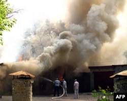 Localnici caută să stingă un foc în Luhansk.