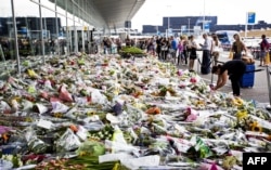 Olandezi în fața unor buchete de flori la aeroportul din Amsterdam pe 25 iulie. Olanda a pierdut 193 de cetățeni în zborul malaezian.