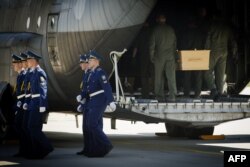 Militari ucrainen i transportă coșciuge astăzi în Harkov.