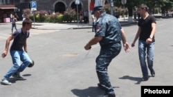 Armenia - A police officer plays football with protesters on Marshal Bagramian Avenue, Yerevan, 25June2015.