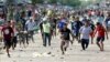 BOLIVIA -- Protesters run, some of them collect stones from the street, during the national strike called by citizen sectors opposed to the re-election of Bolivian President Evo Morales, in Santa Cruz, Bolivia, 23 October 2019. The national strike called 