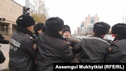 Полицейлер белсенді Дулат Ағаділді (ортада) күштеп ұстап жатқан сәт. Нұр-Сұлтан, 26 қазан 2019 жыл.