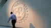 U.S. -- A man walks past the International Monetary Fund logo at its headquarters in Washington, May 10, 2018.