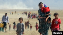 Iraq -- Displaced people from the Yezidi community, fleeing violence from forces loyal to the Islamic State in Sinjar town, walk towards the Syrian border, on the outskirts of Sinjar mountain, near the Syrian border town of Elierbeh of Al-Hasakah Gove