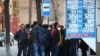 KAZAKHSTAN -- People wearing protective face masks wait in line outside a currency exchange office in Almaty, March 9, 2020