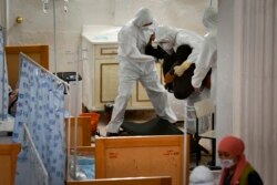 Дәрігерлер коронавирус жұқтыруы мүмкін деген науқасқа ем көрсетіп жатыр.