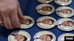 Значкі з партрэтам Сяргея Магніцкага і надпісам «Патрабуем справядлівасьці» на вечарыне памяці Магніцкага ў Маскве.